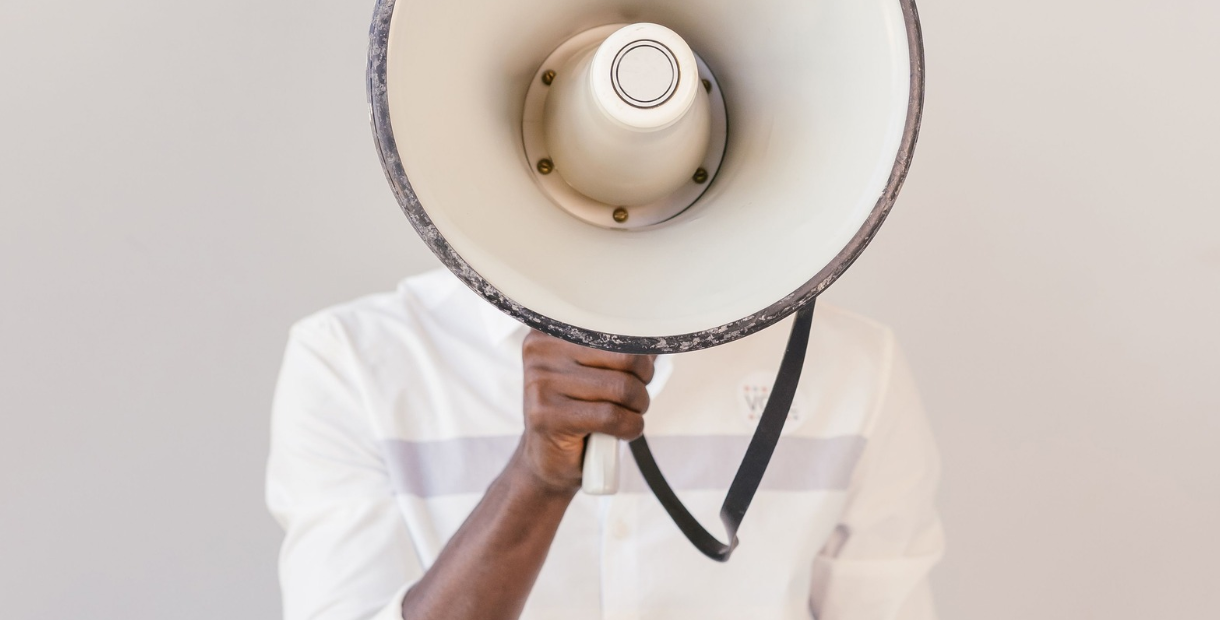 A close up photo of a person holding a megaphone