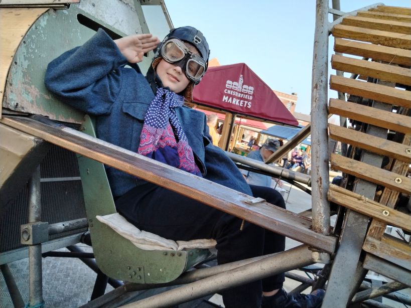 A boy saluting in a replica plane at Chesterfield's 1940s Market 