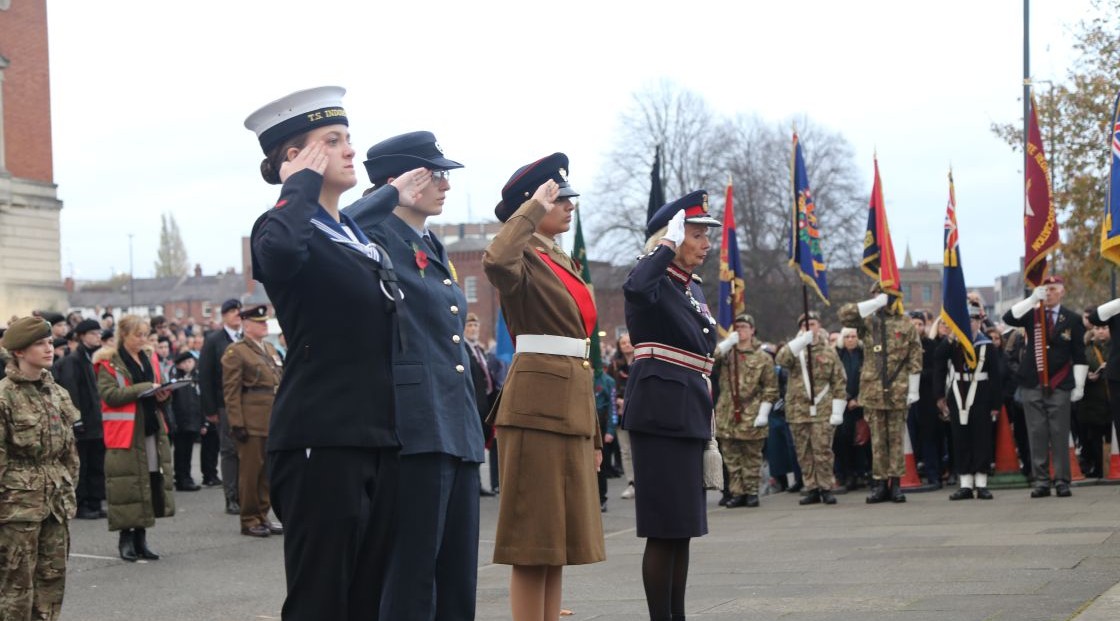 Forces service personnel saluting at war memorial