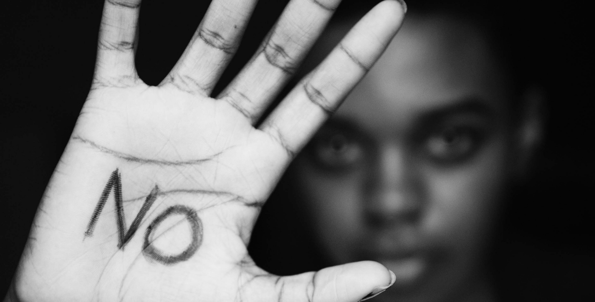 Hand held towards camera with 'NO' written on palm in pen